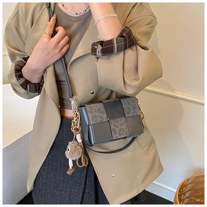 Detail of woven leopard print crossbody bag with plush charm on a khaki trench coat