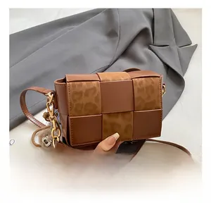 Detail showing woven texture and leopard print panels on brown small square bag