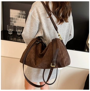 Détail de sac cabas en daim marron foncé avec boucle métallique dorée raffinée