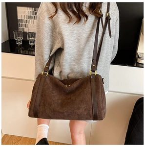 Détail du cabas en daim marron foncé avec bandoulière en cuir et boucles dorées