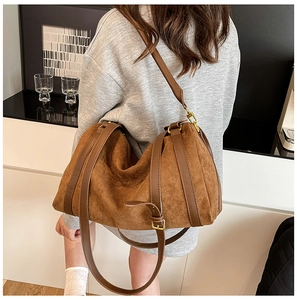 Détail du sac cabas en daim mat avec bandoulières réglables en cuir et finitions dorées