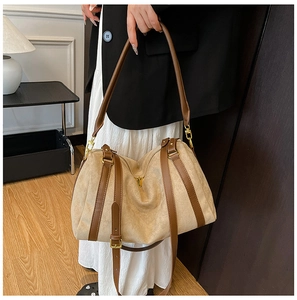 Détail du sac cabas en daim kaki avec des lanières marron et des boucles dorées