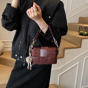 Retro burgundy woven leather crossbody bag with leopard texture and plush pendant charm