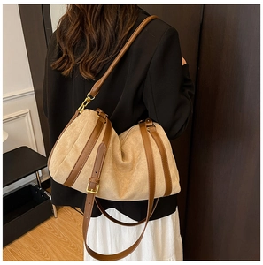 Détail du cabas en daim beige avec bordure en cuir marron et bandoulière réglable