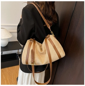 Détail d'un sac hobo en toile avec garniture en cuir et ferrures dorées sur modèle