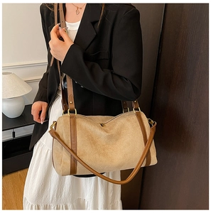 Détail du cabas en daim mat avec poignées en cuir marron dans un cadre chaleureux