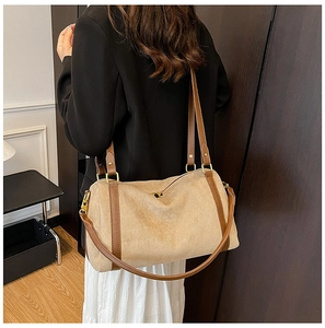 Gros plan d'un grand sac cabas en daim kaki avec des anses en cuir marron sur l'épaule