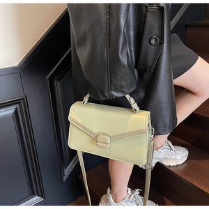 Détail du sac à main vert sauge montrant la boucle carrée et la poignée supérieure