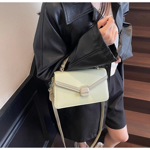 Sac bandoulière vert menthe avec veste en cuir et boucles argent sur modèle