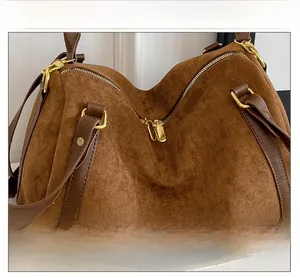 Gros plan détaillé du sac cabas en daim marron avec anses en cuir et finitions dorées