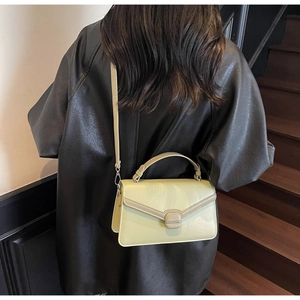 Sac à bandoulière vert jaune clair porté par un mannequin avec une veste en cuir élégante