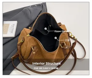 Gros plan de l'intérieur spacieux avec poche zippée d'un sac Boston en daim marron