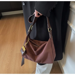 Detail of vintage suede tote bag with golden metal chain and mini pouch accessory