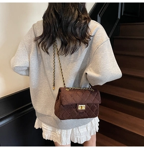 Détail du sac bandoulière matelassé marron foncé avec fermoir doré et texture velours