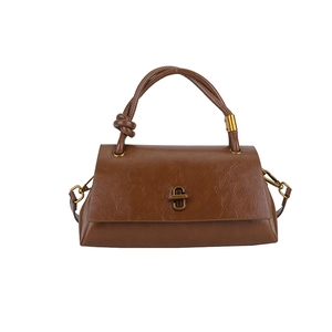 Brown vintage style leather handbag with retro metal buckle and knotted strap on white background