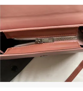 Detail view of a smooth silver metal zipper on a premium pink leather crossbody handbag
