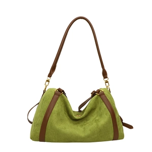 Sac cabas en daim vert avec bordures et bandoulières en cuir marron sur fond blanc