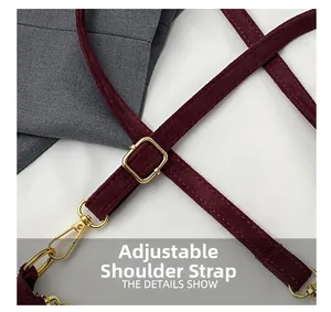 Close-up of adjustable burgundy suede strap with golden metal buckles and lobster clasp