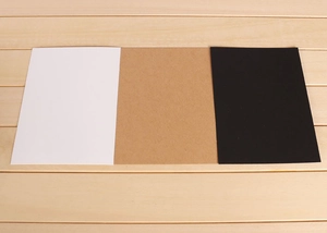 Three-color thick kraft cardstock set in white, brown, and black on a wooden background