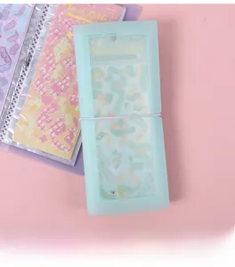 Detail of mint green sticker organizer with white elastic strap and narrow pockets