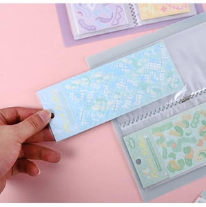 Detail of AGUGU sticker storage book with transparent sleeves and pastel ribbon stickers