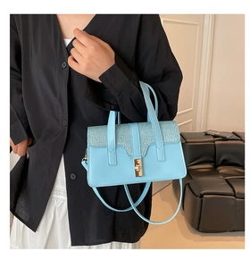 Détail du sac bandoulière bleu clair avec rabat scintillant et fermoir en métal chic