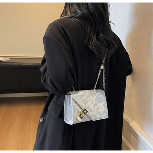 Detail of silver marble texture handbag featuring premium gold and black metal clasp