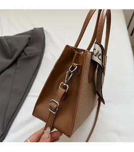 Gros plan d'un sac à main bicolore avec bandoulière en cuir et foulard décoratif en soie