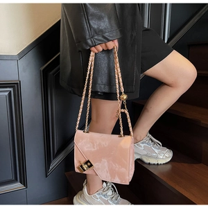 Detailed shot of pink marble texture chain bag with a golden turn-lock on a fashion flap bag