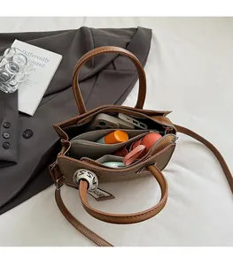 Vue intérieure du sac à main en cuir marron montrant la grande capacité et les poches