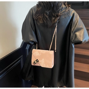 Detail shot of a pink chain crossbody bag with marble print and black gold lock