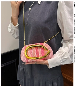 Detail of pink and orange woven straw bag featuring a stylish large golden C-buckle