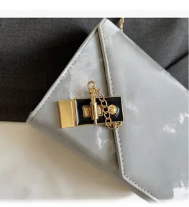Close-up of golden square buckle and metallic water ripple texture on the silver chain bag
