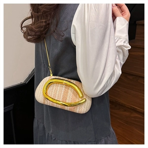 Detail of woven straw texture and stylish gold metal handle on a round crossbody bag