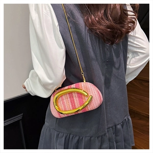 Detail of woven tweed crossbody box bag with gold metal handle and oversized ring buckle