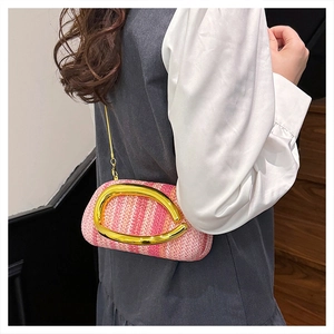 Detail of pink and white woven straw box bag with large gold handle and metal chain