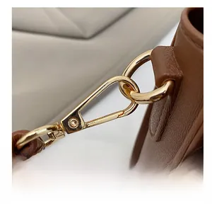 Macro detail of high-quality gold spring clasp and natural texture brown leather strap