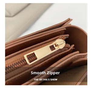 Macro view of smooth golden zipper and organized inner compartments of brown leather bag