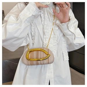 Detailed macro of woven straw clutch texture and sleek golden metallic handle