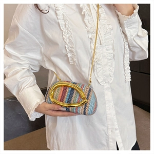 Detail of colorful woven texture and gold metal handle on straw evening clutch bag
