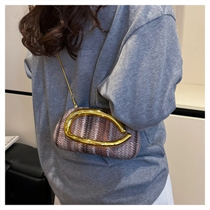 Detail of tweed weave texture and modern golden streamlined metal handle on handbag