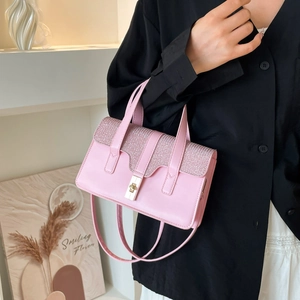 Pink PU leather handbag with glitter flap and gold buckle shown by model in white setting