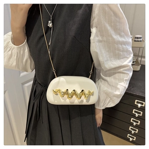 White semi-circular crossbody bag with wave metal trim and gold chain on model
