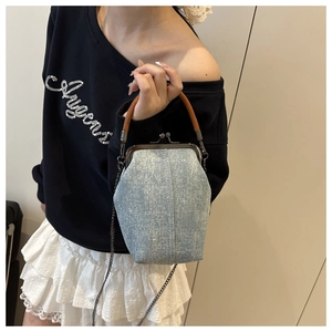 Detail of denim shell bag with sparkling rhinestones and vintage metal clasp closure
