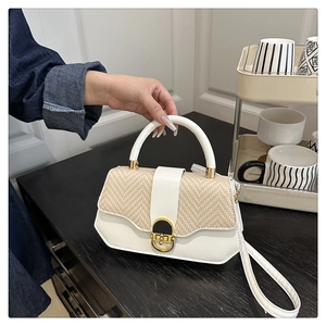 Détail du sac à main en cuir blanc et paille tressée avec fermoir rotatif doré élégant