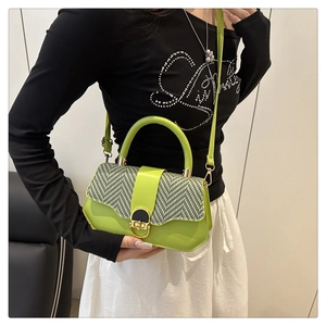 Détail du sac à main vert néon avec rabat en tissu chevron et finitions dorées sur modèle