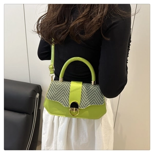 Détail du sac bandoulière en cuir vert et pied-de-poule avec fermoir doré rond