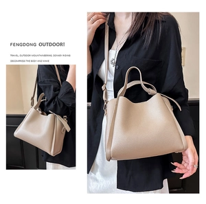 Détail du sac à main en cuir grainé beige montrant la texture et la bandoulière