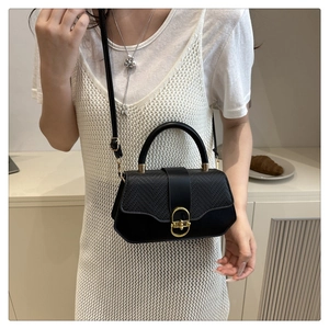 Détail du sac bandoulière hexagonal noir avec cuir motif lézard et fermoir doré