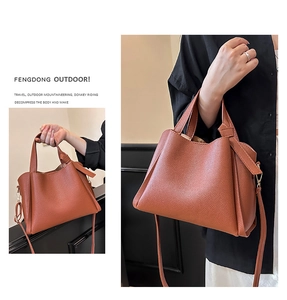 Détails de la texture cuir litchi et poignées souples sur ce sac à main caramel